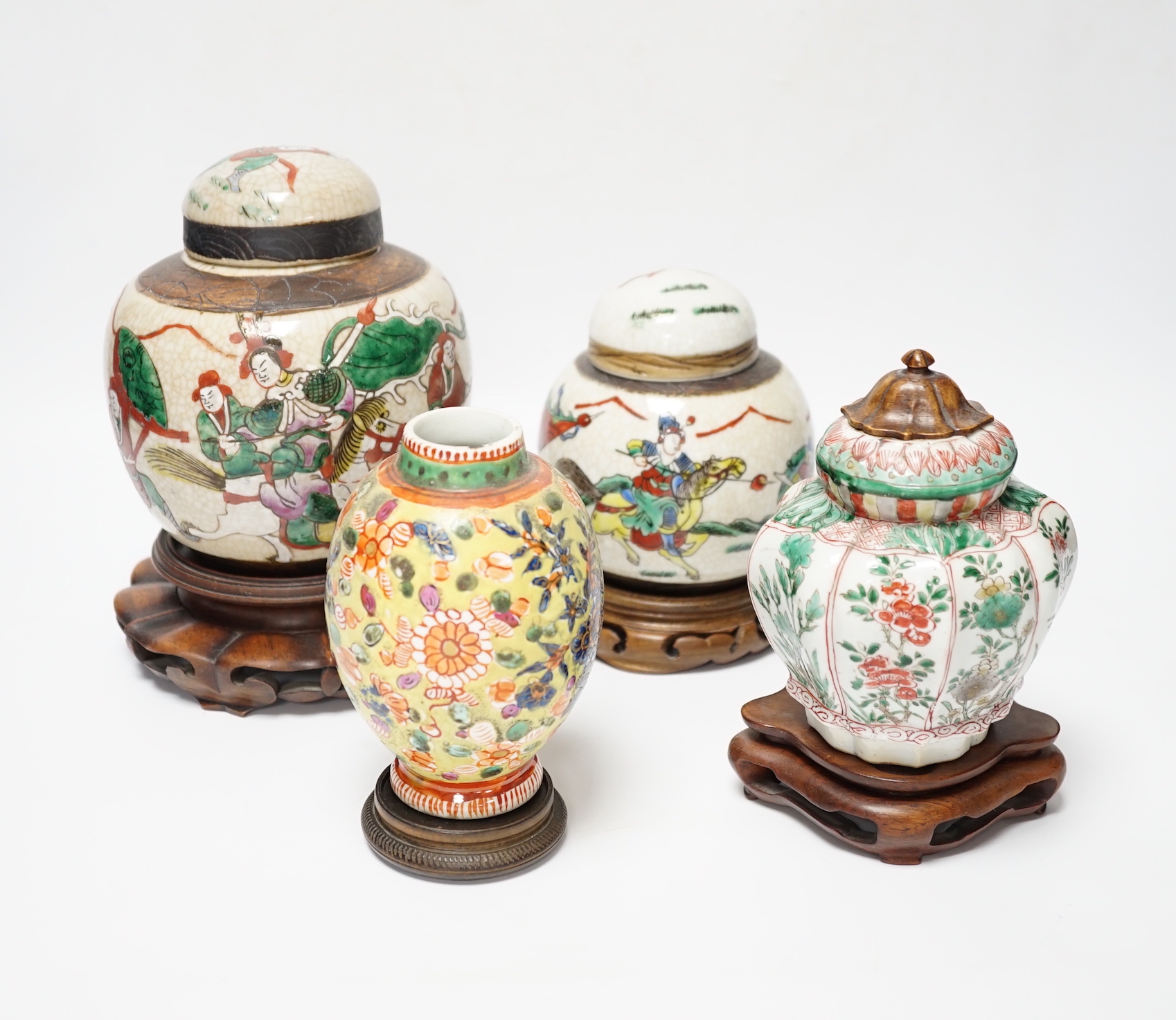 A Chinese famille verte vase, Kangxi period (cut down) and three Chinese polychrome jars with hardwood stands, tallest 19cm